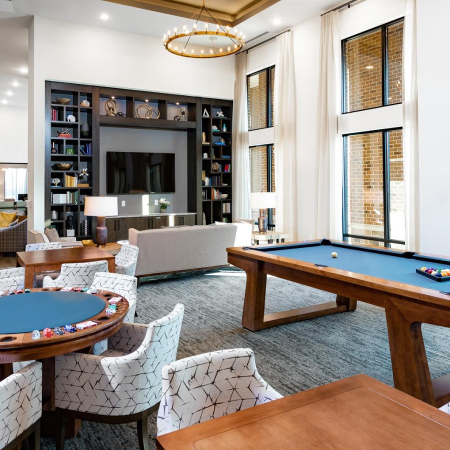 a room with a pool table and chairs